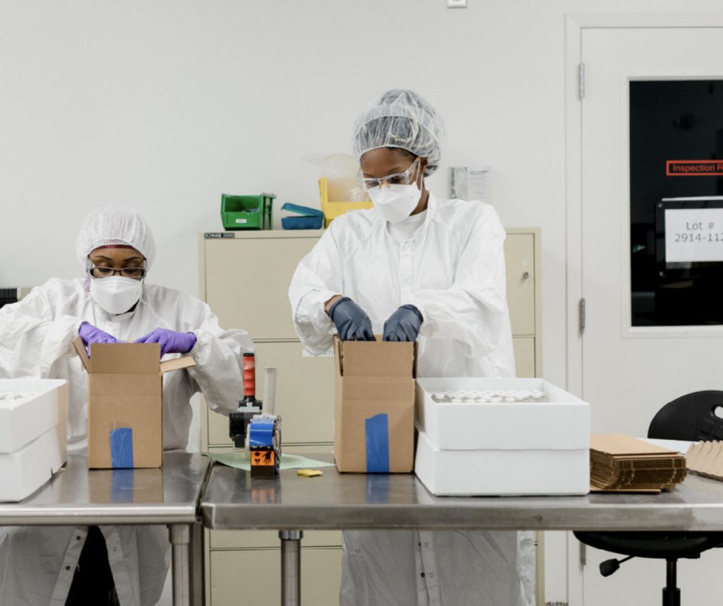 Two workers in lab opening boxes